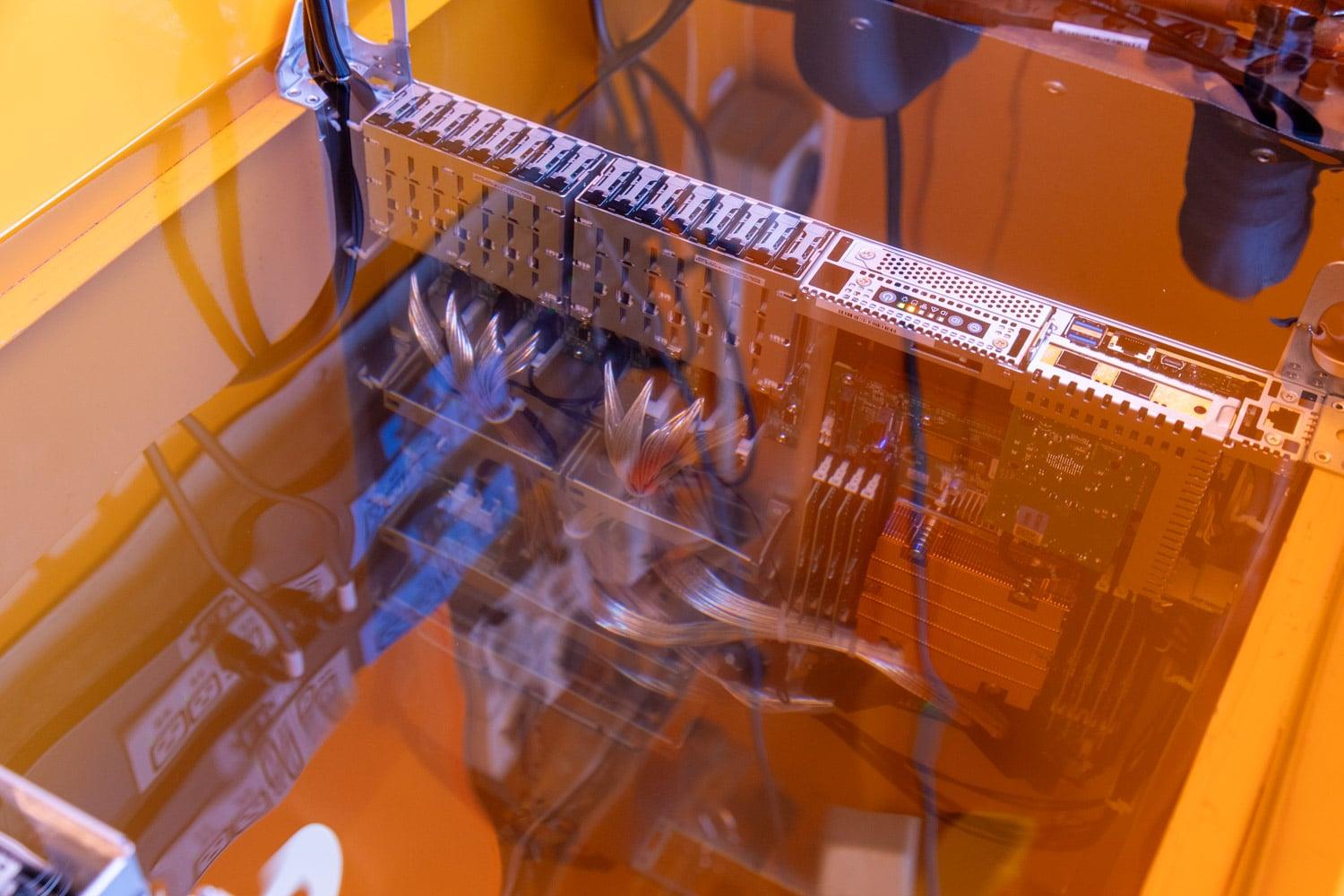 Server blades submerged in immersion-cooling tanks inside a data center