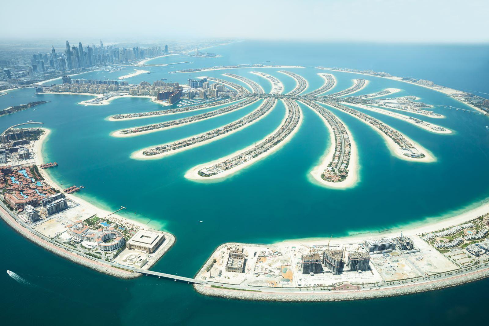 Aerial view of a palm-shaped island megadevelopment rising from the sea