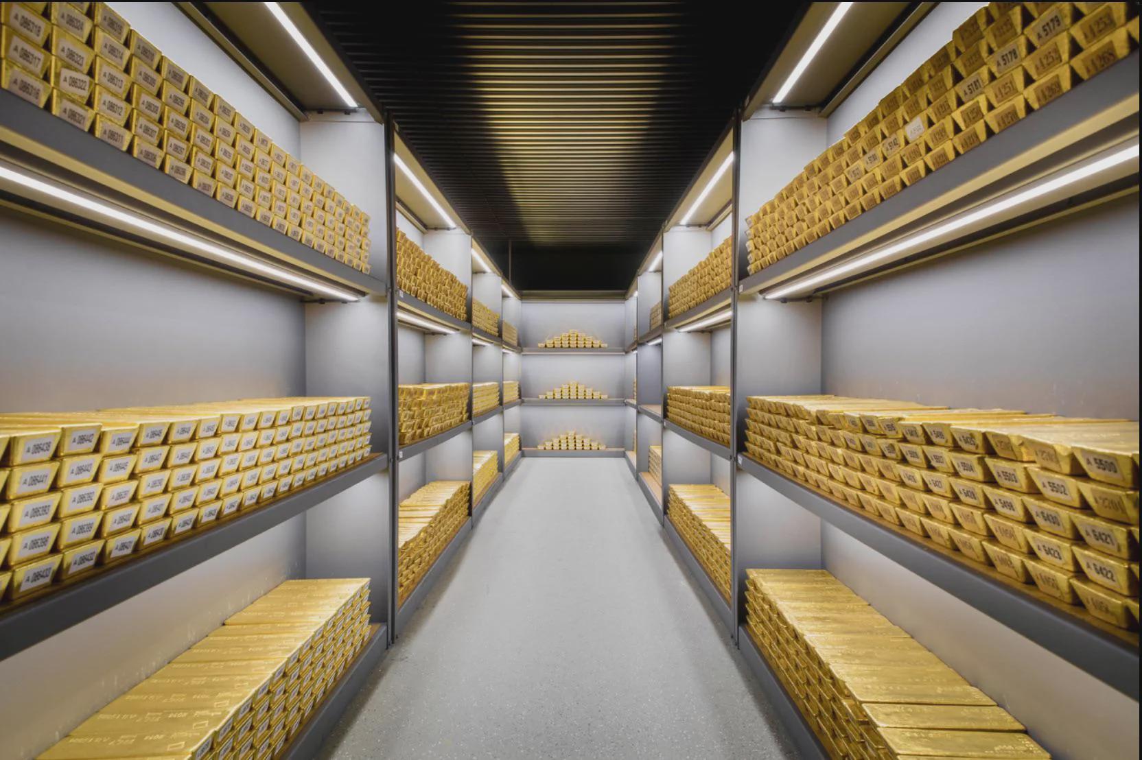 Rows of gold bullion bars stacked inside a sovereign vault